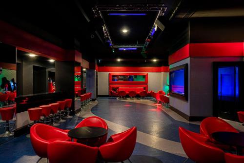 a room with red chairs and a bar at Leodikya Kirman Premium - Ultra All Inclusive in Okurcalar