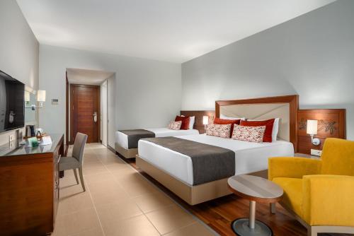 a hotel room with two beds and a desk at Leodikya Kirman Premium - Ultra All Inclusive in Okurcalar