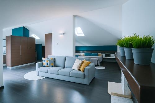 sala de estar con sofá y macetas en Borgo d'Oro Loft, en Bérgamo