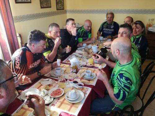 a group of people sitting around a table eating food at Ai Tre Parchi Bed And Bike in Randazzo