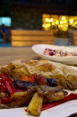 a plate of food with food on a table at NeoKulla Hotel - Hikers Hive in Valbonë