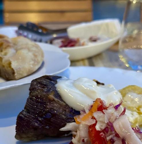 a plate of food with meat and vegetables on a table at NeoKulla Hotel - Hikers Hive in Valbonë