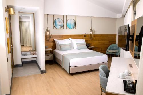 a bedroom with a large white bed and a table at Miramare Beach Hotel - Ultra All Inclusive in Side
