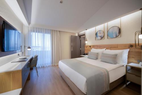 a hotel room with a large bed and a desk at Miramare Beach Hotel - Ultra All Inclusive in Side