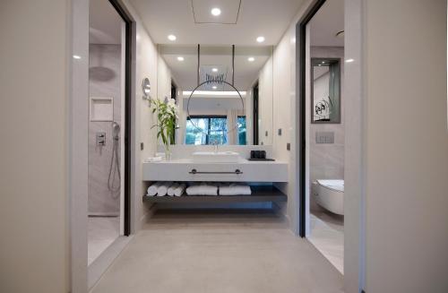 a white bathroom with a sink and a toilet at Miramare Beach Hotel - Ultra All Inclusive in Side