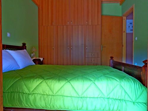a bedroom with a large green bed with wooden cabinets at Menina Farm Kalamata Countryside in Perivolákia
