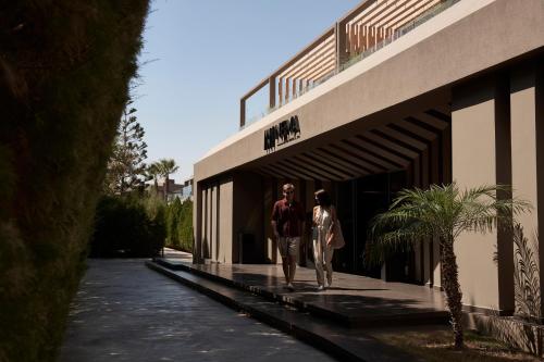a man and woman walking outside of a building at NEMA Design Hotel & Spa - Adults Only in Hersonissos