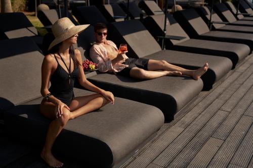 a man and a woman sitting on rows of chairs at NEMA Design Hotel & Spa - Adults Only in Hersonissos