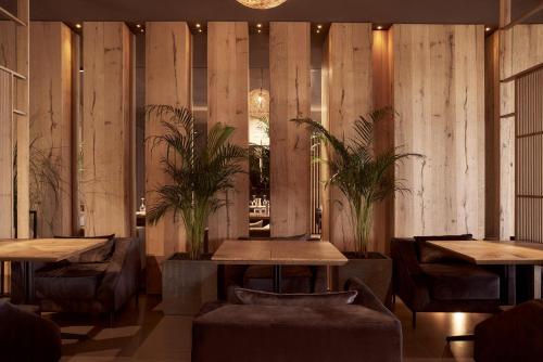 a restaurant with wooden walls and tables and chairs at NEMA Design Hotel & Spa - Adults Only in Hersonissos