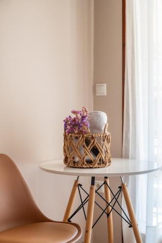 a cake on a glass table with a basket of flowers at Filoxenia Apartments in Mytilini