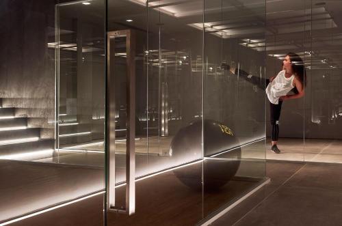 a woman standing inside of a glass wall at NEMA Design Hotel & Spa - Adults Only in Hersonissos