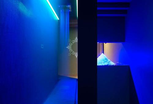 a blue room with a bed and a lamp at NEMA Design Hotel & Spa - Adults Only in Hersonissos