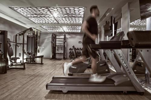 a man running on a treadmill in a gym at NEMA Design Hotel & Spa - Adults Only in Hersonissos