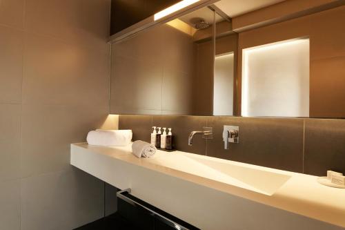 a bathroom with a sink and a mirror at NEMA Design Hotel & Spa - Adults Only in Hersonissos