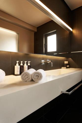 a bathroom with a sink and a mirror at NEMA Design Hotel & Spa - Adults Only in Hersonissos