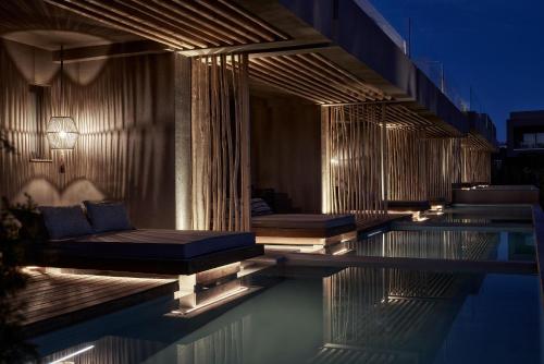 a swimming pool with a couch on the side of a building at NEMA Design Hotel & Spa - Adults Only in Hersonissos