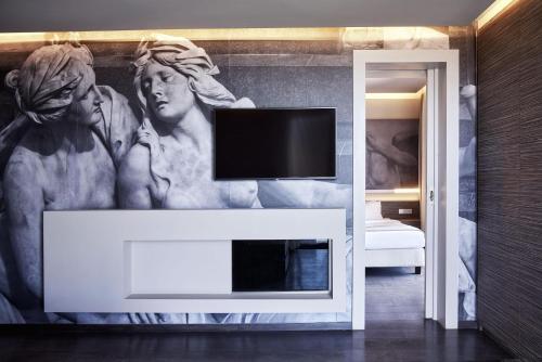 a living room with a tv above a fireplace at NEMA Design Hotel & Spa - Adults Only in Hersonissos