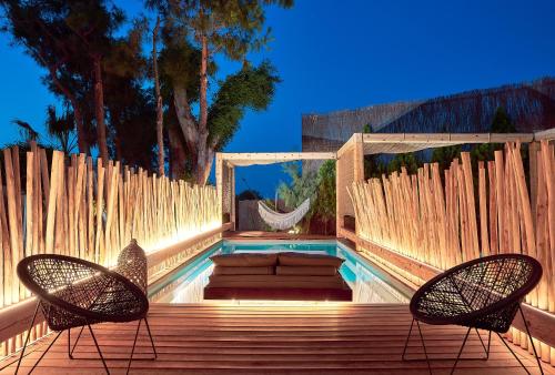 a pool with two chairs and a couch on a wooden deck at NEMA Design Hotel & Spa - Adults Only in Hersonissos