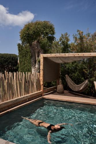 a woman is laying in a swimming pool at NEMA Design Hotel & Spa - Adults Only in Hersonissos