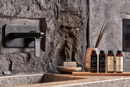 a sink with bottles of essential oils on a counter at NEMA Design Hotel & Spa - Adults Only in Hersonissos