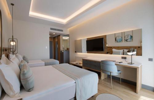 a bedroom with a bed and a desk and a television at Miramare Beach Hotel - Ultra All Inclusive in Side