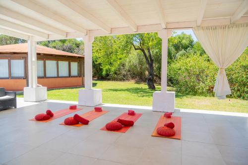 a group of red pillows on a dance floor at Felix Hotels - Galanias Hotel & Retreat in Bari Sardo
