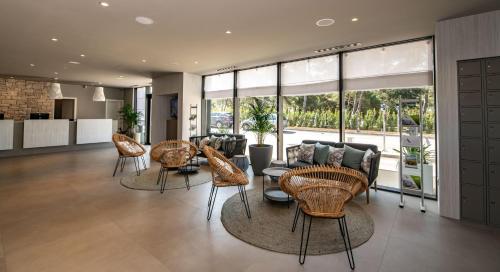 a living room with chairs and tables and windows at Arena Grand Kazela Camping Homes in Medulin