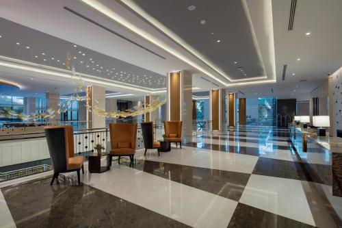 a lobby with chairs and tables in a building at Trendy Lara in Lara