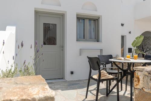 a patio with a table and chairs and a door at Adama's Suites in Naxos Chora