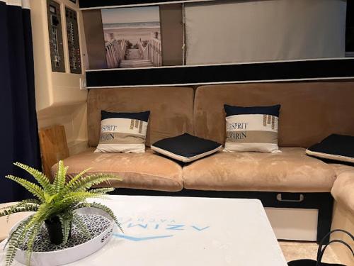 a room with a couch and a table with a plant at IPANEMA - JOLI BATEAU à QUAI in Sète