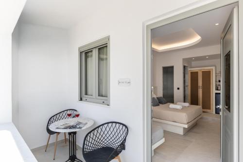 a room with a table and chairs and a bedroom at Adama's Suites in Naxos Chora
