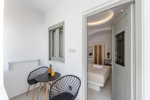 a room with a table and two chairs and a bedroom at Adama's Suites in Naxos Chora