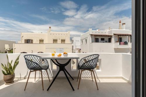 a balcony with a table and chairs on a roof at Adama's Suites in Naxos Chora