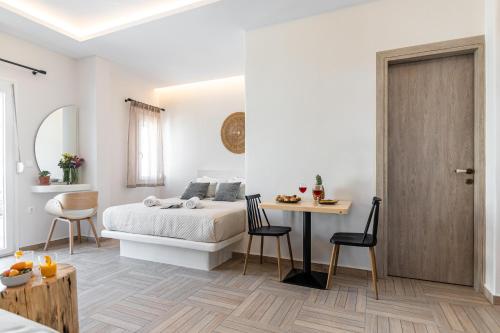 a bedroom with a bed and a table and chairs at Adama's Suites in Naxos Chora