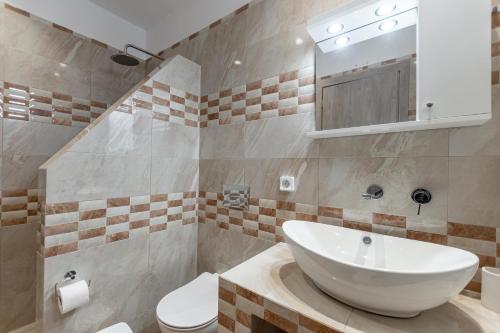a bathroom with a white sink and a toilet at Adama's Suites in Naxos Chora
