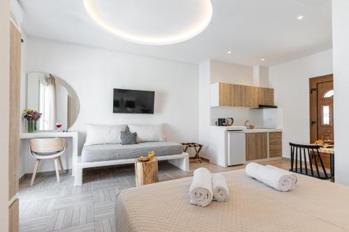a bedroom with a bed and a living room with a kitchen at Adama's Suites in Naxos Chora