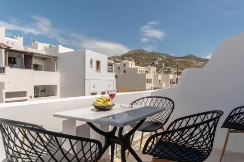 a table and chairs on a balcony with a glass of wine at Adama's Suites in Naxos Chora