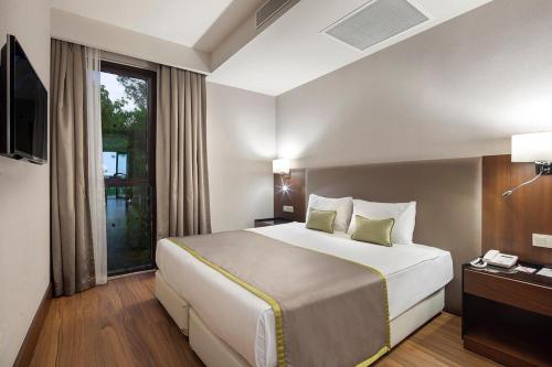 a hotel room with a large bed and a window at Trendy Lara in Lara