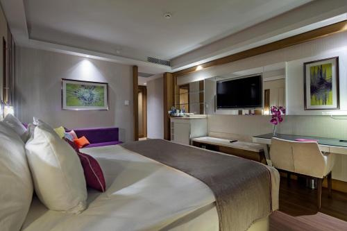 a hotel room with a large bed and a desk at Trendy Lara in Lara