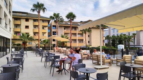 a group of people sitting at tables on a patio at Side Zeugma Hotel - Adult Only 16 Plus in Side