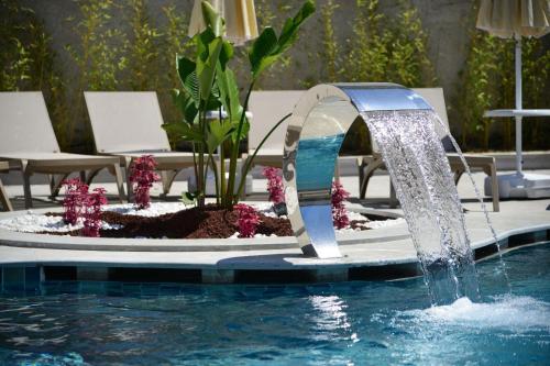 a pool with a water fountain in a swimming pool at Side Zeugma Hotel - Adult Only 16 Plus in Side