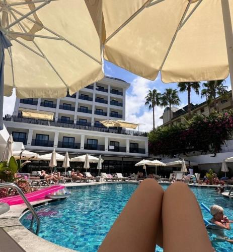a woman with her feet in the swimming pool at a hotel at Side Zeugma Hotel - Adult Only 16 Plus in Side