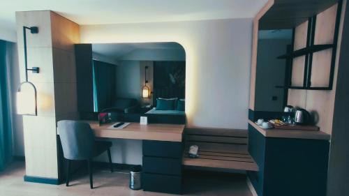 a room with a desk with a bed in the background at Side Zeugma Hotel - Adult Only 16 Plus in Side