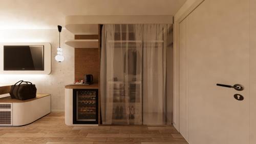 a glass shower in a room with a tv at Q Ella Beach Hotel in Side