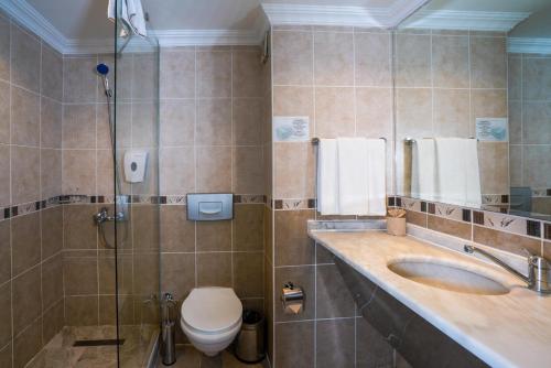 a bathroom with a toilet and a sink and a shower at Q Ella Beach Hotel in Side