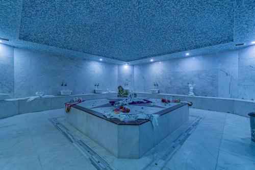 a large bathroom with a tub in a room at Q Ella Beach Hotel in Side