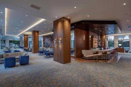 a lobby of a hotel with blue chairs and tables at Trendy Lara in Lara