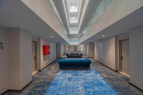 a hallway with a blue couch in a building at Q Ella Beach Hotel in Side