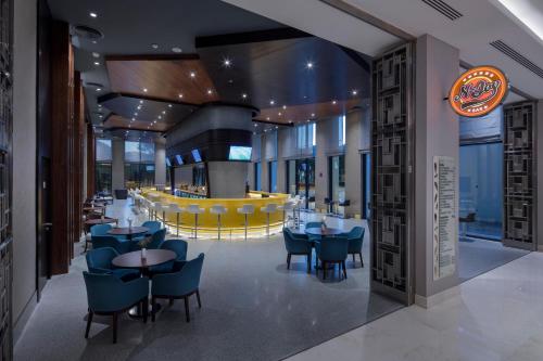 a restaurant with blue chairs and tables and a bar at Trendy Lara in Lara