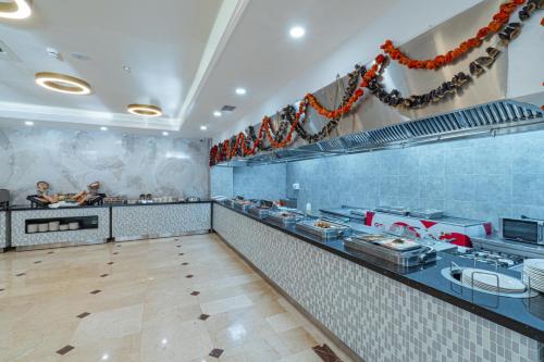 a restaurant kitchen with a counter with people preparing food at Q Ella Beach Hotel in Side